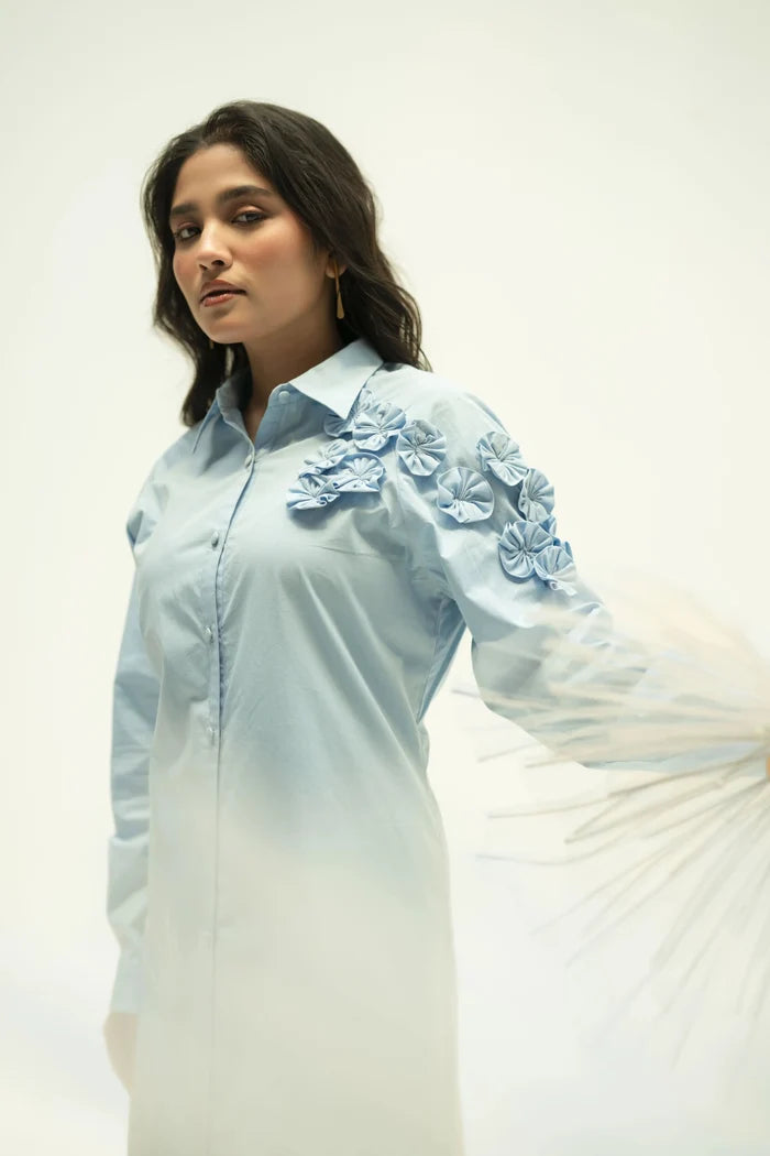 Model in pastel blue dress showing full length silhouette and gentle fabric movement in studio.