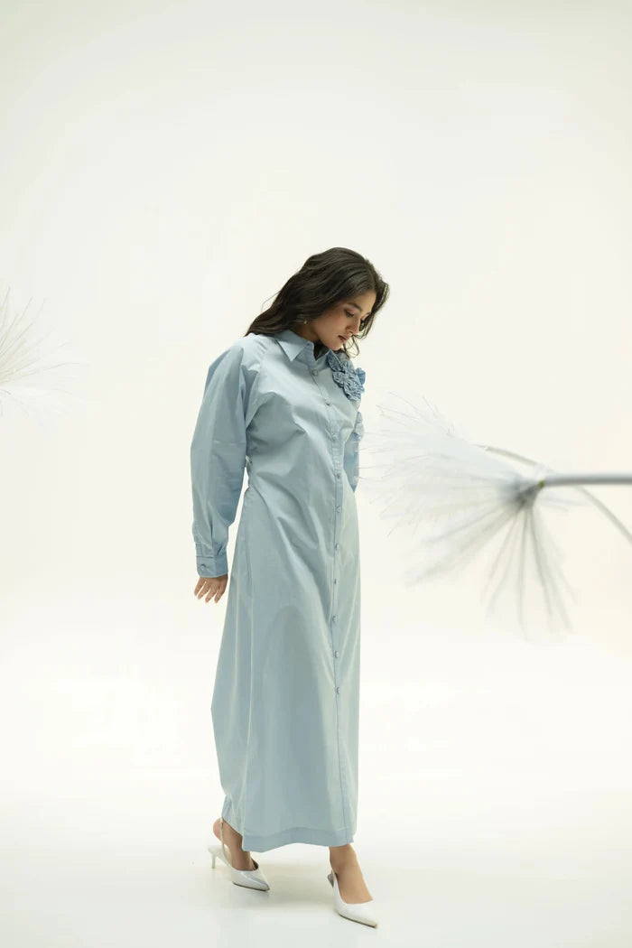 Side profile of model wearing Alora blue corsage dress with subtle pleats against light background.