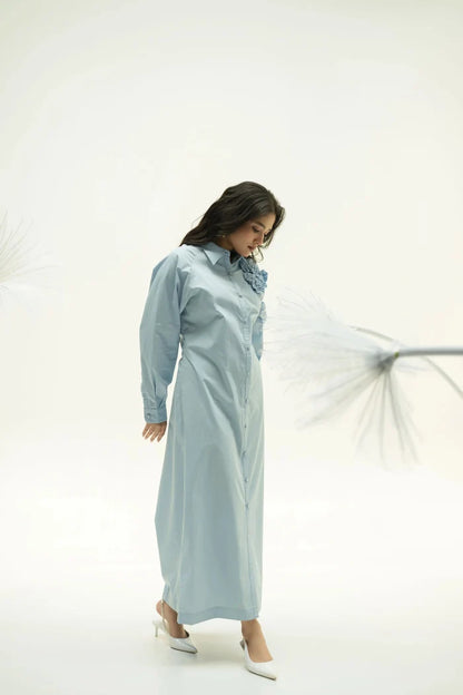 Side profile of model wearing Alora blue corsage dress with subtle pleats against light background.