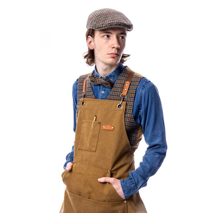 Male model wearing a tan utility apron standing against a white background.