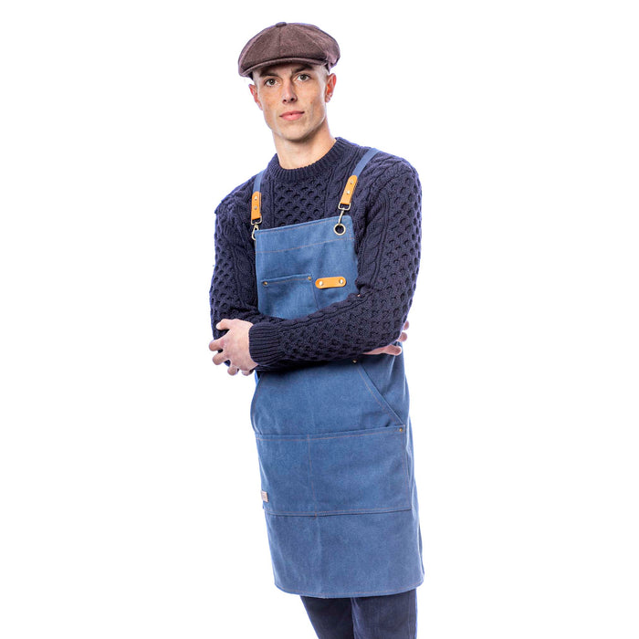 Canvas utility apron in navy waxed cotton worn by male model