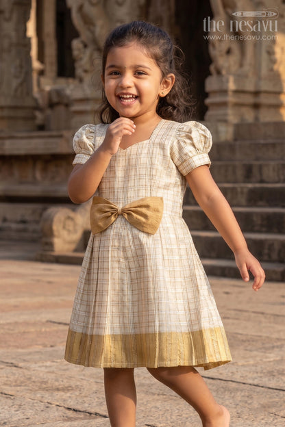The Nesavu Silk Frock Girls Short Frocks for Party in Beige Silk with Gold Bow Embellishment and Checked Pleated Design Nesavu 16 (1Y) / Cream SF1010B-16 Nesavu Girls Short Frocks Party Beige Silk Gold Checked Pleats Bow Embellishment