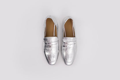 large sized 10 womens Pair of silver loafers on a light gray background