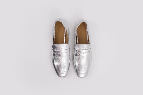 large sized 10 womens Pair of silver loafers on a light gray background