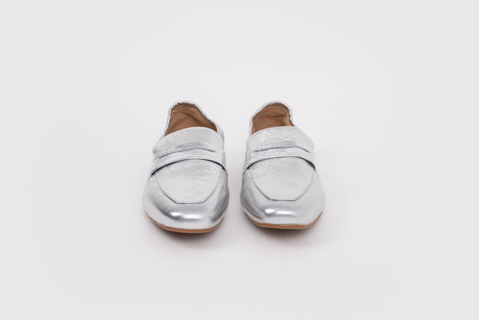 Large sized 9 womens Pair of silver loafers on a white background