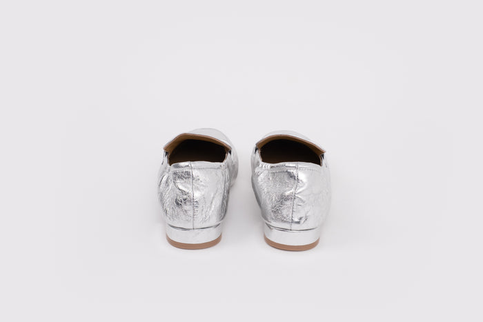 Large sized 9 womens Pair of silver metallic loafers on a white background