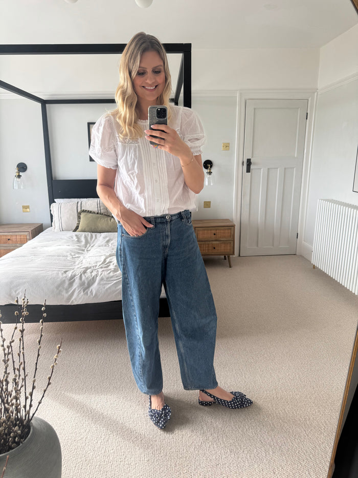 Tall woman wearing navy polkadot bow flats in larger sizes 8-12